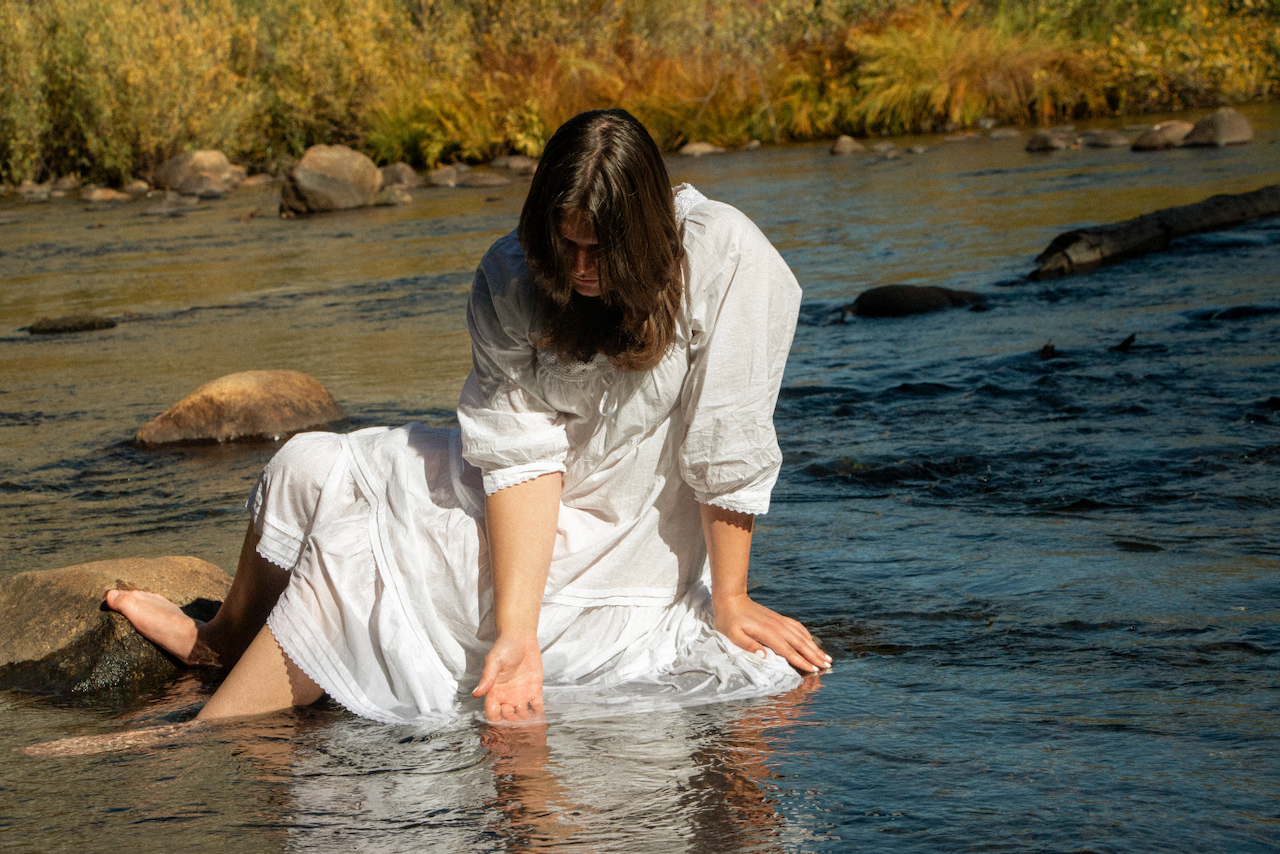 A figure bathes in a stream