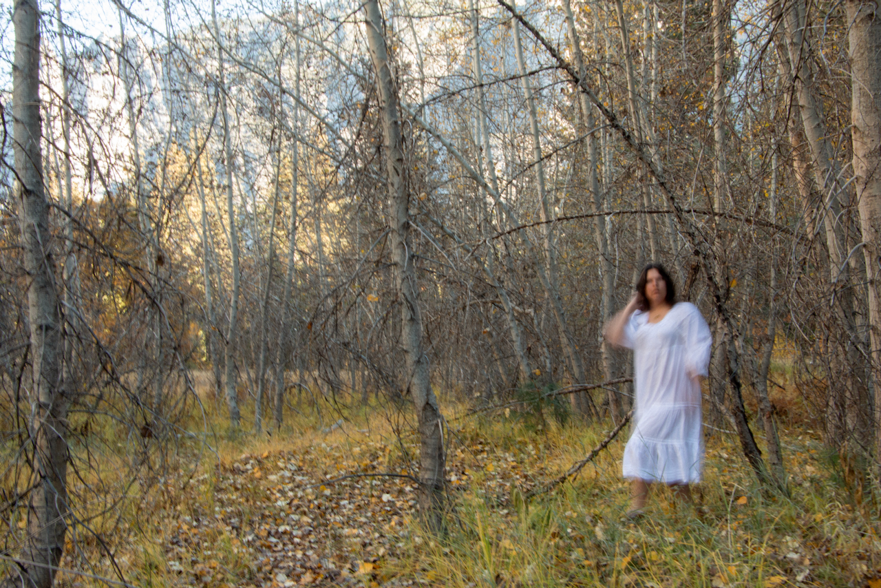A blurry figure stands amidst the forest