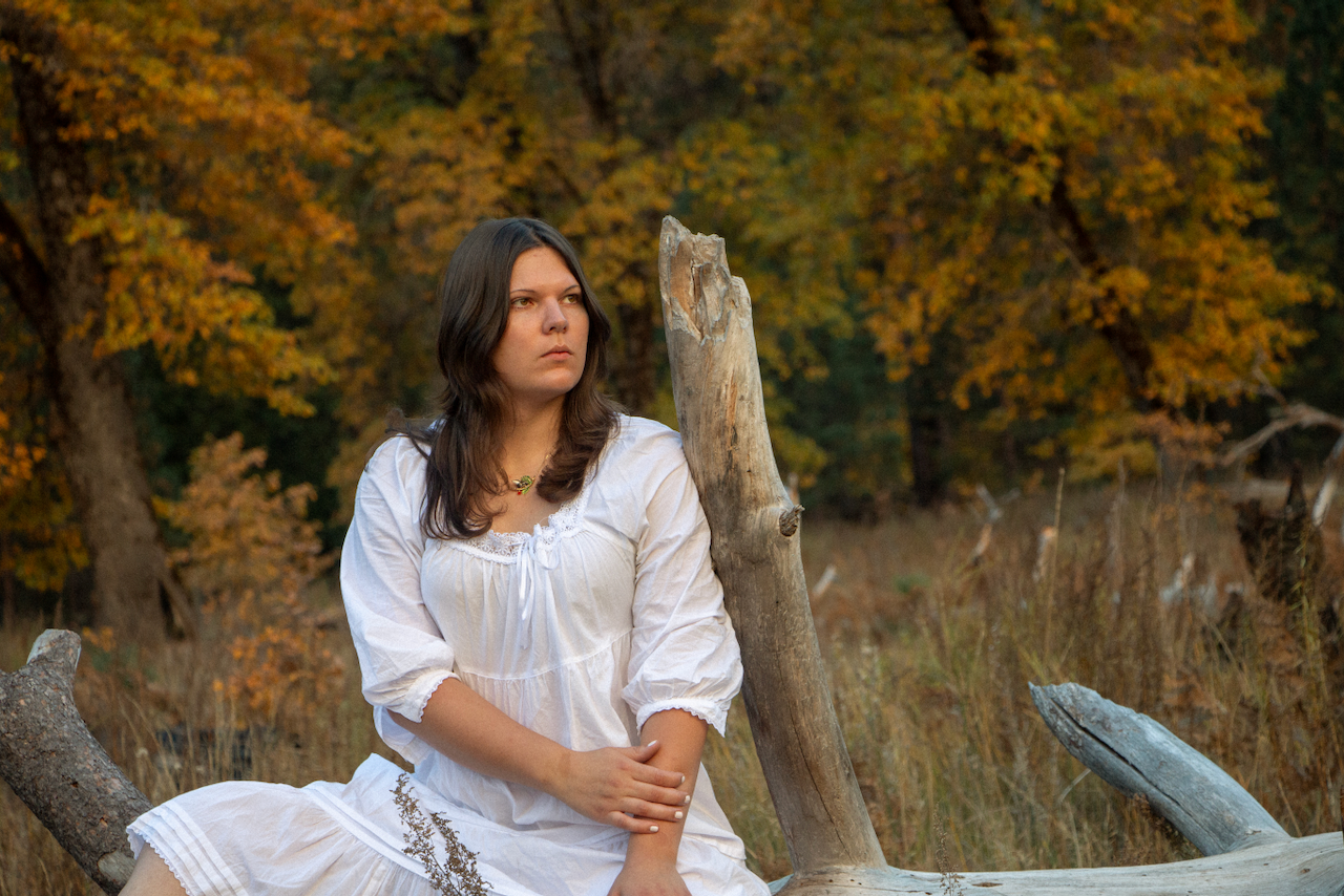 A figure sits on a log